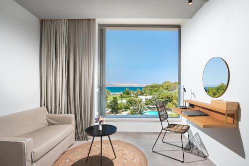 a living room with a view of the ocean at Caravia Beach Hotel in Marmari