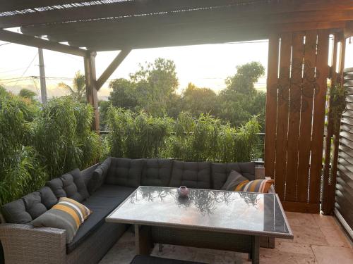 a patio with a couch and a table at case à roches in Saint-Gilles les Bains