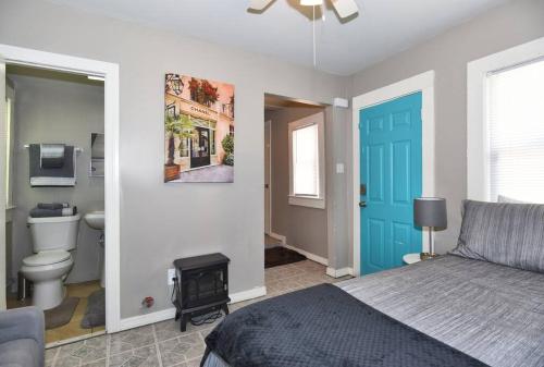 um quarto com uma cama e uma porta azul em CHERRY ST LITTLE LOVE HOUSE* SHOP*DINE* RT 66*EXPO CENTER*BOK*DOWNTOWN em Tulsa