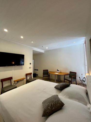a bedroom with a bed and a table with chairs at VENEZIANA Boutique Hotel Superior in Koper