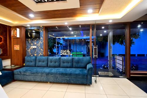 a living room with a blue couch in a room at Hotel Hallmark By THC Group in Kota