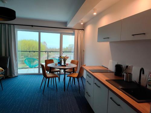 a kitchen and dining room with a table and a window at Apartamenty Mistral in Jastarnia