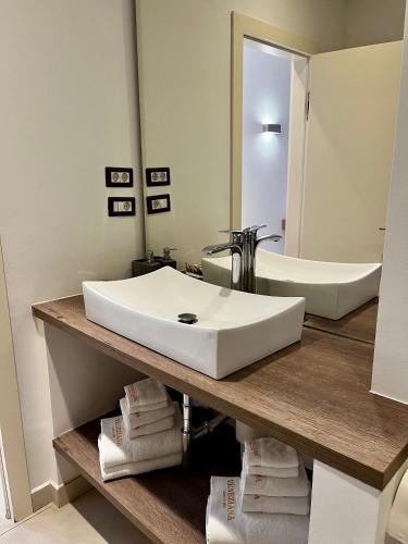 a bathroom with a white sink and a bath tub at VENEZIANA Boutique Hotel Superior in Koper