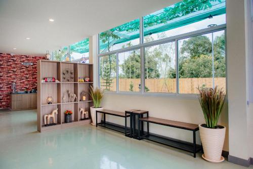 a lobby with two benches and a large window at ONE Chumphon Hotel in Chumphon