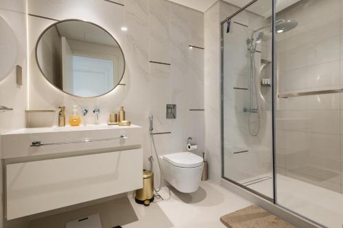 a bathroom with a shower and a toilet and a mirror at Beach Vista Tower 1 - 1BR Apartment - Allsopp&Allsopp in Dubai