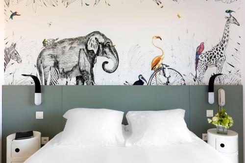 a bedroom with a bed and a mural of animals at Hotel Alcyon in Porto-Vecchio