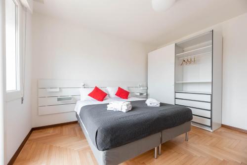 een slaapkamer met een bed met rode kussens en een spiegel bij Appartamento sul fiume al Portello in Padua