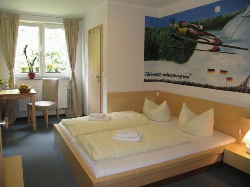 a bedroom with a large bed with two towels on it at Hotel & Gasthaus Sterngrund in Zella-Mehlis