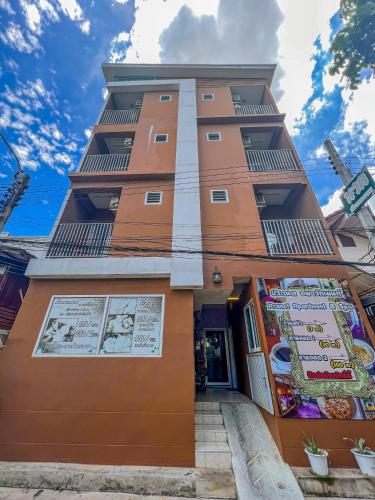 a tall building with signs on the side of it at Pranot Apartment & Spa in Nonthaburi