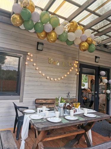a table with gold and green balloons hanging from a ceiling at sosnowelowe in Lamkowo