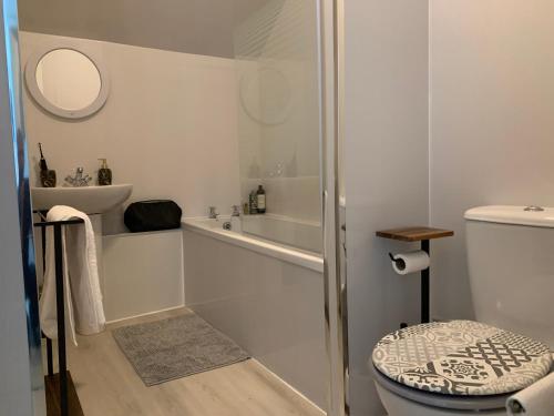 a white bathroom with a tub and a toilet at Lovely 2 Bedroom Apartment in Central Location in Greenock