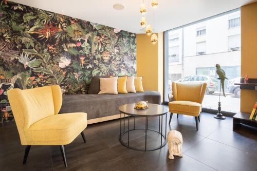 a living room with a couch and two chairs and a dog at Prince Albert Lyon Bercy in Paris