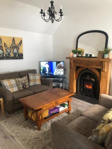 a living room with a table and a fireplace at Entire Cottage The Nest, Omeath near Carlingford 