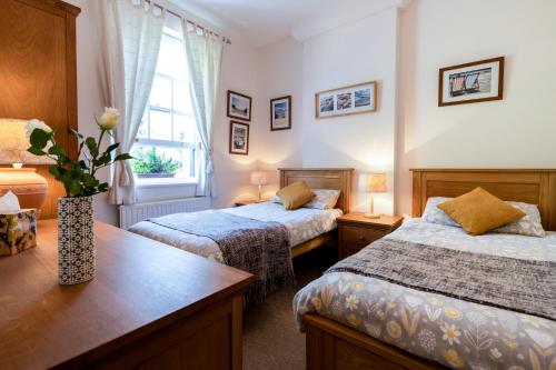 Een bed of bedden in een kamer bij The Old Coastguard Station