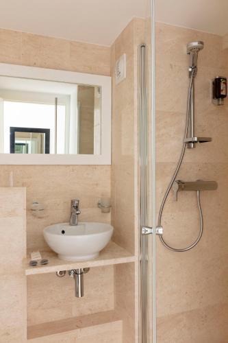a bathroom with a sink and a shower at Hotel Alcyon in Porto-Vecchio