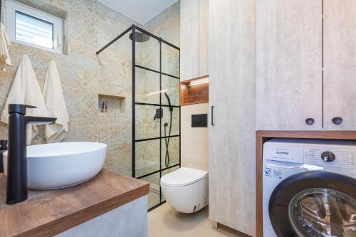 a bathroom with a sink and a washing machine at Dubrovnik 4 Star Apartment in Dubrovnik