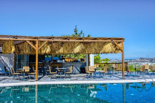 a resort with a swimming pool with chairs and a table at Atalanti Boutique Hotel - Adults Only in Faliraki