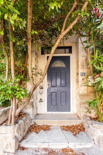 une porte noire sur une maison arborée dans l'établissement Slice of Castle in Aubais, very charming house, à Aubais