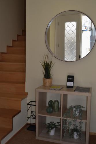 a mirror on a wall next to a stairway at Glamour Guest House in Viana do Castelo