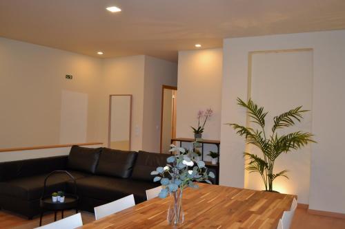 sala de estar con sofá negro y mesa de madera en Glamour Guest House, en Viana do Castelo