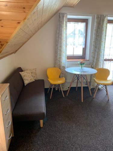 a living room with a couch and a table at Penzion U Orla in Petříkov