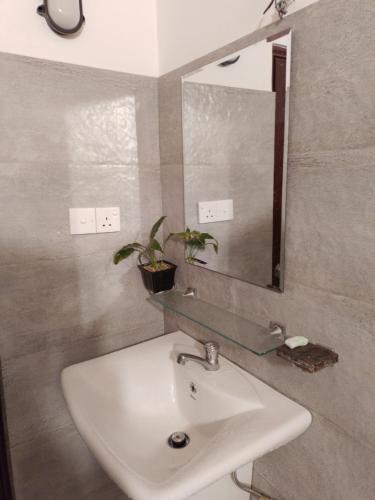 W łazience znajduje się umywalka i lustro. w obiekcie COCO Rooms w mieście Galle