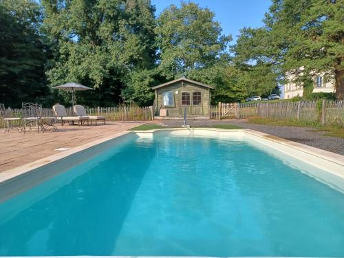 une piscine avec de l'eau bleue devant une maison dans l'établissement Domaine de Savignac, à Chabanais