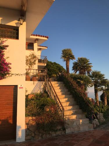 eine Treppe, die zu einem Haus mit Palmen führt in der Unterkunft Villa Panorama 360 in Lloret de Mar