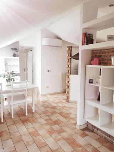 une cuisine et une salle à manger avec une table et des étagères dans l'établissement Appartamento mansardato Civitanova Marche, à Civitanova Marche