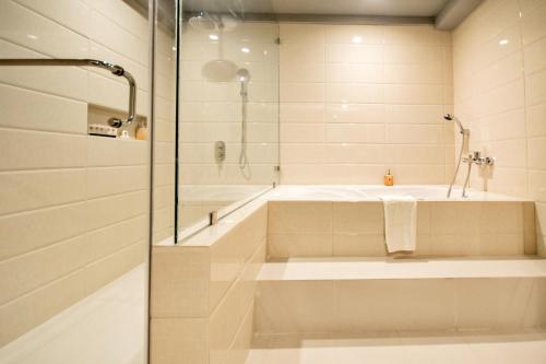 a bathroom with a bath tub and a shower at Commander Suites de Boracay in Boracay