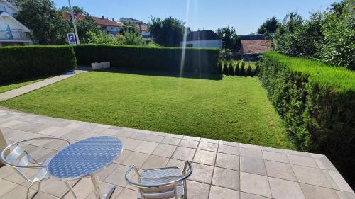 a table and chairs on a patio with a lawn at Sobe villa 118 in Kragujevac