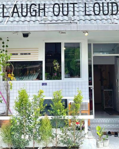 a store front with a sign that reads laugh out loud at Cafe home in Chiang Mai