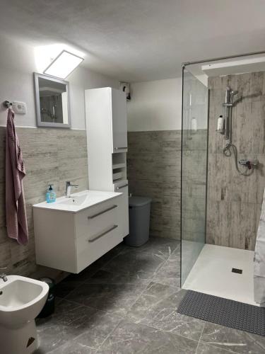 a bathroom with a white sink and a shower at Apartma Ročica in Kobarid