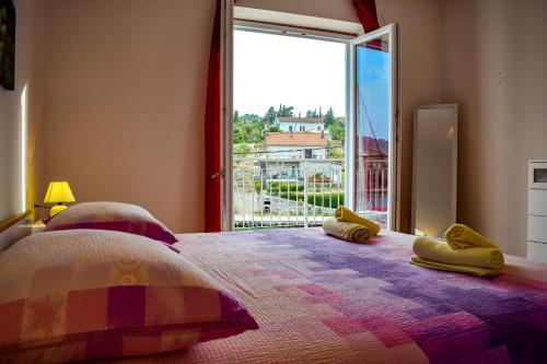 - une chambre avec un lit et une grande fenêtre dans l'établissement Maslinčica, à Veli Iž