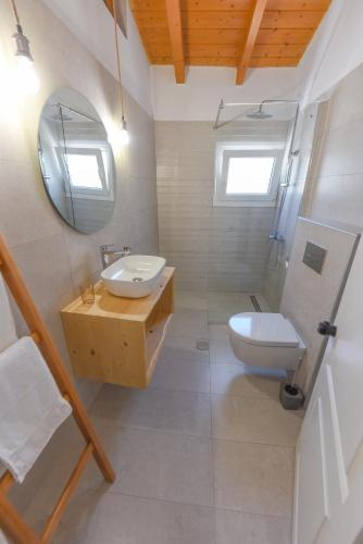 a bathroom with a toilet and a sink and a mirror at Merabello Beach House in Samos