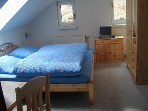a bedroom with a bed with a blue comforter at Hotel & Gasthaus Sterngrund in Zella-Mehlis