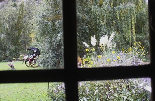 een raam met uitzicht op een tuin bij Las Vertientes Lodge in San Martín de los Andes