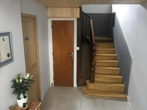 a hallway with a wooden door and a staircase at Luxury Guest House in the Centre of Argeles Gazost in Argelès-Gazost