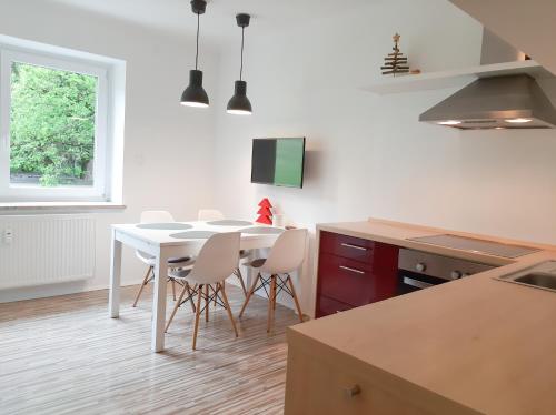 kuchnia z białym stołem i białymi krzesłami w obiekcie Apartman Ramsau w mieście Ramsau am Dachstein