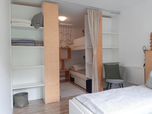 a bedroom with a bed and a closet with shelves at Apartman Ramsau in Ramsau am Dachstein