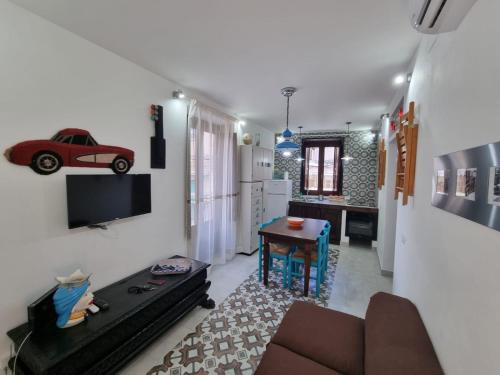 a living room with a couch and a red car on the wall at Casa viotti Le fuoriserie in Palermo