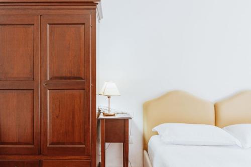 a bedroom with a wooden cabinet next to a bed at Vallicciola Nature Hotel in Tempio Pausania