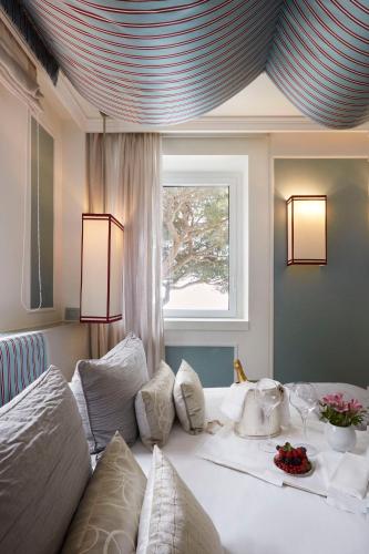 a bedroom with a bed with white pillows and a window at Eight Hotel Paraggi in Santa Margherita Ligure
