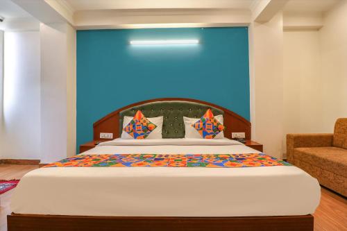 a bedroom with a large bed with a blue wall at FabHotel Lime Tree in New Delhi
