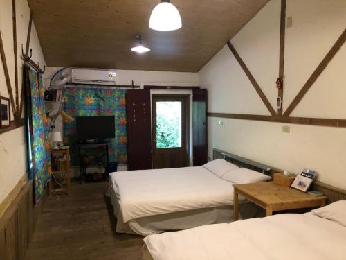 a room with two beds and a television in it at Jiufen Gourd Stone TreeHouse 137 in Ruifang