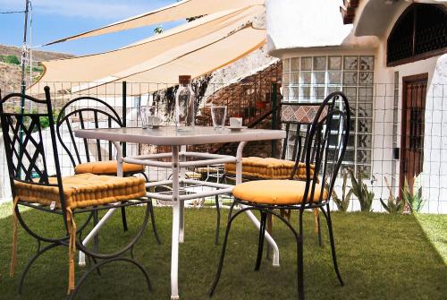 einen Tisch und Stühle auf dem Rasen in der Unterkunft Las Cuevas de Monachil in Monachil