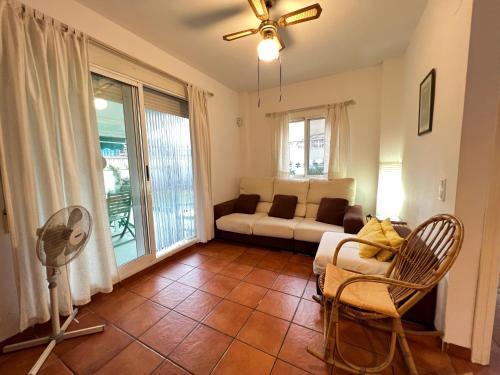 ein Wohnzimmer mit einem Sofa und einem Ventilator in der Unterkunft Apartamento con jardín Atalaya Canet in Canet d'en Berenguer