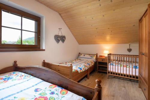 a bedroom with two beds and a crib at Chalupa Anička - Terchová in Terchová
