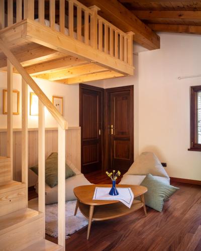a living room with a loft bed and a table at La Casetta, appartamento con vista lago e montagne in San Zeno di Montagna