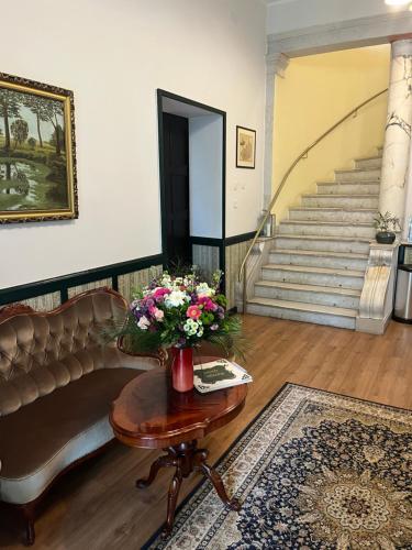 a living room with a couch and a table with flowers at Pałac Victoria in Mgowo